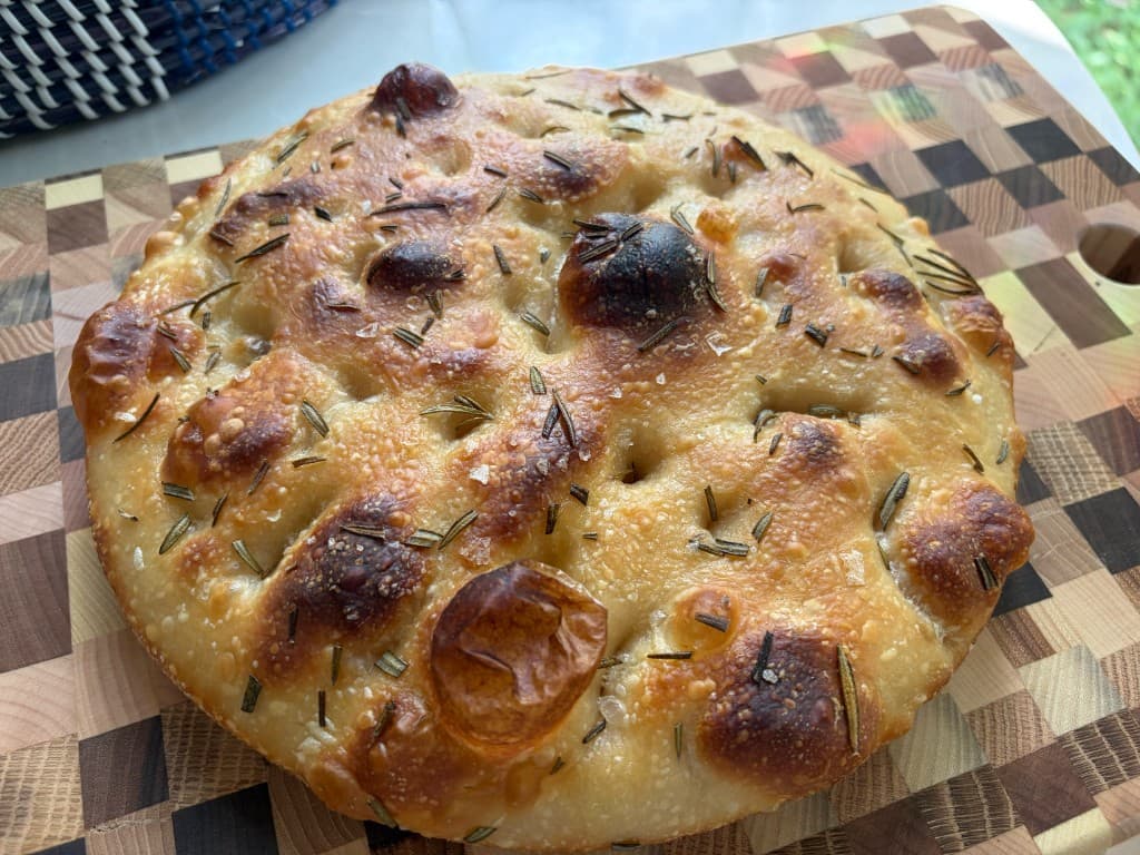 Rosemary focaccia loaves with coarse salt on a wooden board