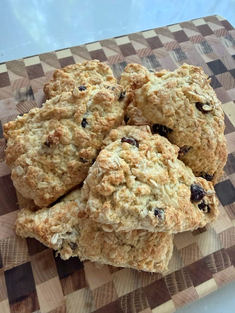 Golden cranberry oat scones on a checkered cutting board